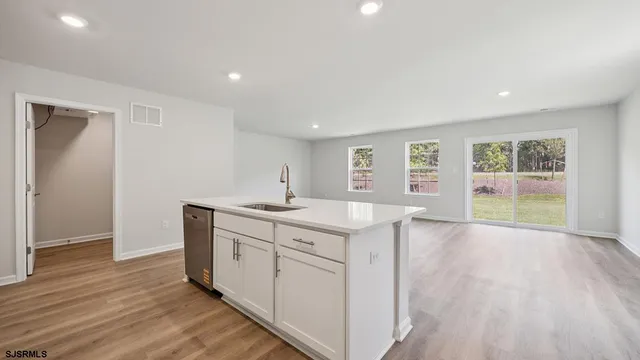 a view of a kitchen with wooden floor and a sink