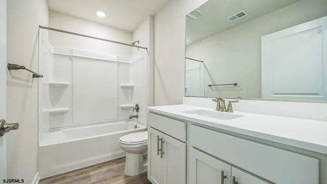 a bathroom with a sink toilet vanity and shower