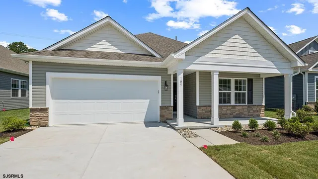 a front view of a house with a garden and plants