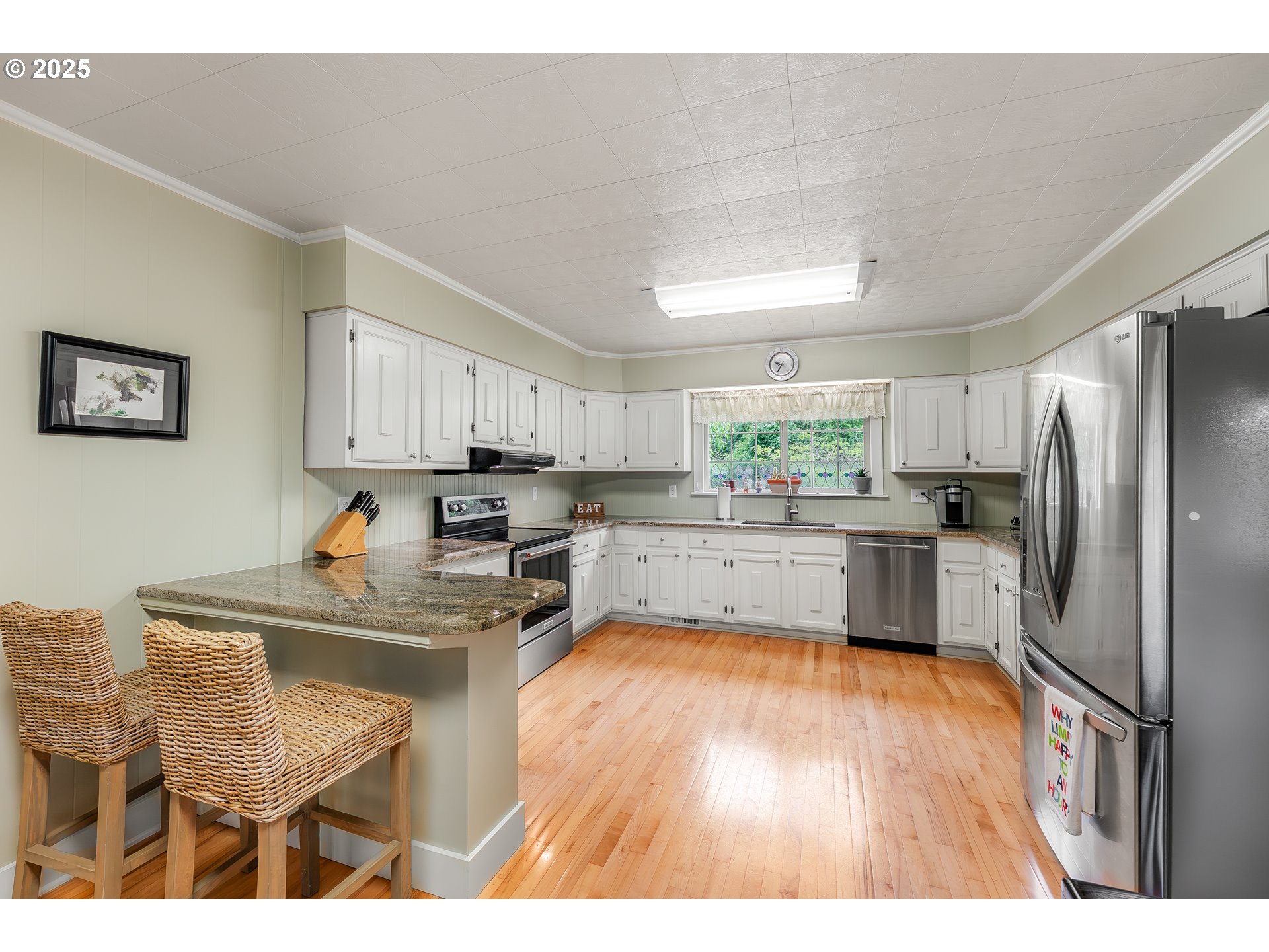 4500 Glenbrook Loop Road Riddle, OR 97469 - Photo 8 of 46 a kitchen with granite countertop a refrigerator cabinets wooden floor and a dining table