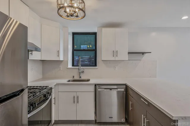 a kitchen with stainless steel appliances a white cabinets and a stove top oven