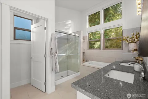 a bathroom with a granite countertop tub shower and sink