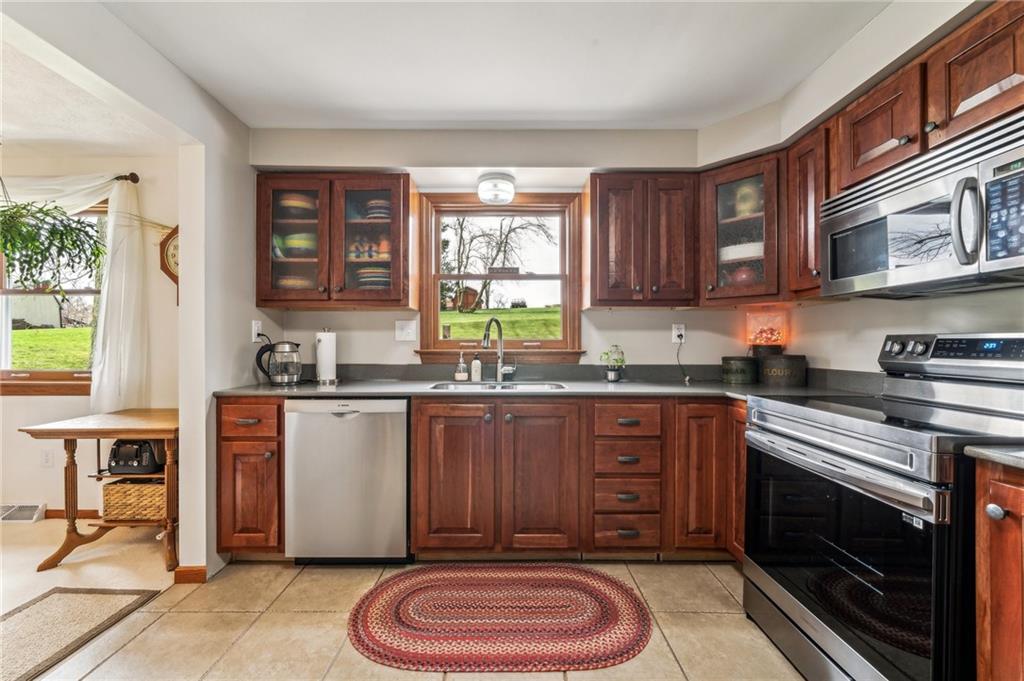 22 Wolfram Road Washington, PA 15301 - Photo 14 of 41 a kitchen with stainless steel appliances granite countertop a stove a sink dishwasher and cabinets with wooden floor