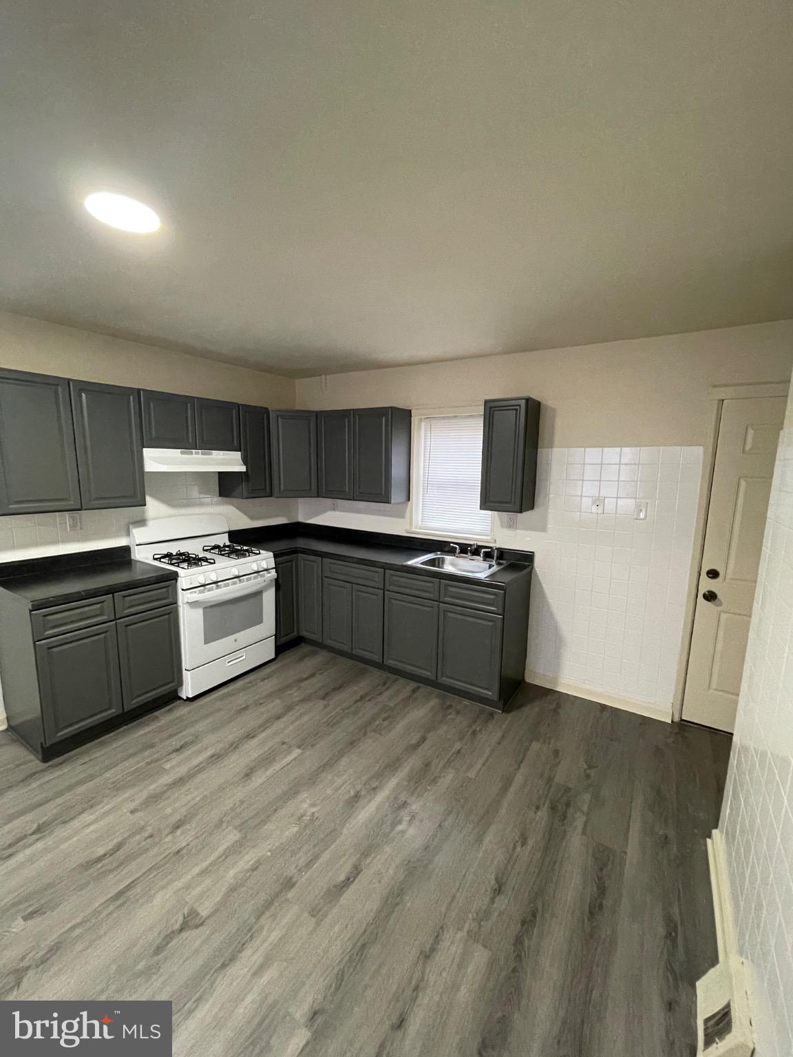 2441 North 5th Street Philadelphia, PA 19133 - Photo 3 of 19 a large kitchen with a stove top oven and sink
