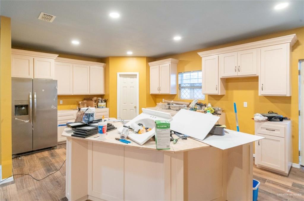 4 Mile 4 Road Penitas, TX 78576 - Photo 11 of 12 a kitchen with a refrigerator a stove a sink dishwasher with a dining table and chairs with wooden floor