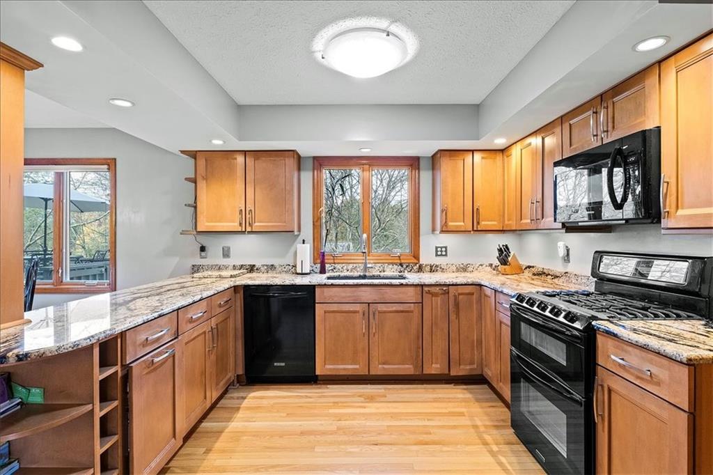 205 Constance Drive McKees Rocks, PA 15136 - Photo 10 of 25 a kitchen with stainless steel appliances granite countertop wooden cabinets a stove a sink and a window