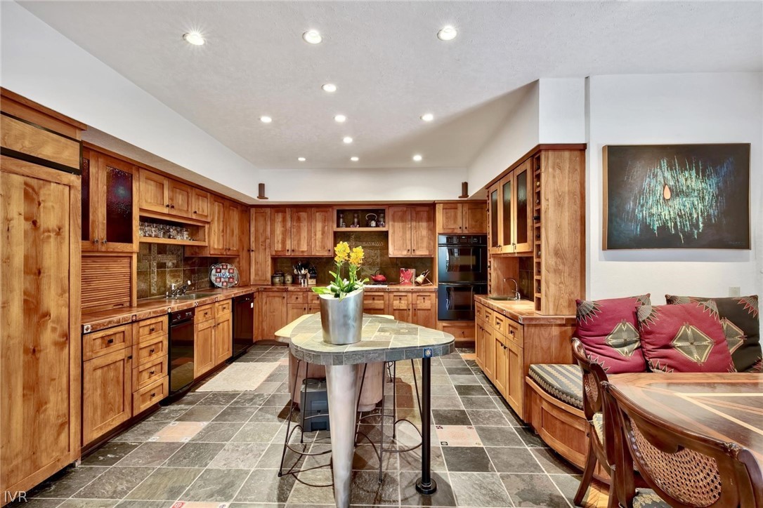 976 Tee Court Incline Village, NV 89451 - Photo 16 of 34 a kitchen with stainless steel appliances kitchen island granite countertop a dining table chairs and stove top oven