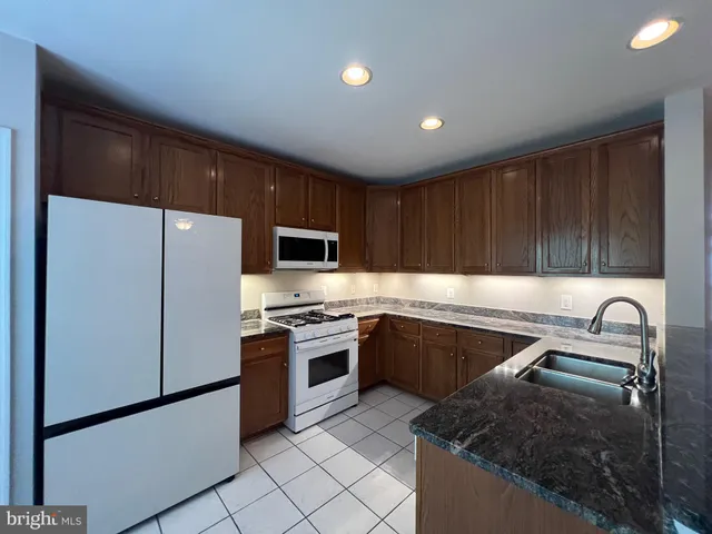 a view of a kitchen with stainless steel appliances wooden floor and a large window