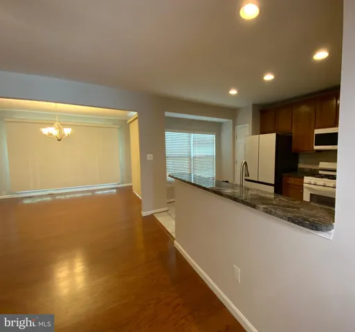 a kitchen with stainless steel appliances granite countertop a refrigerator a stove a sink and a microwave