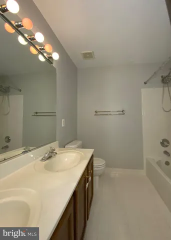 an empty room with a chandelier fan and closet area