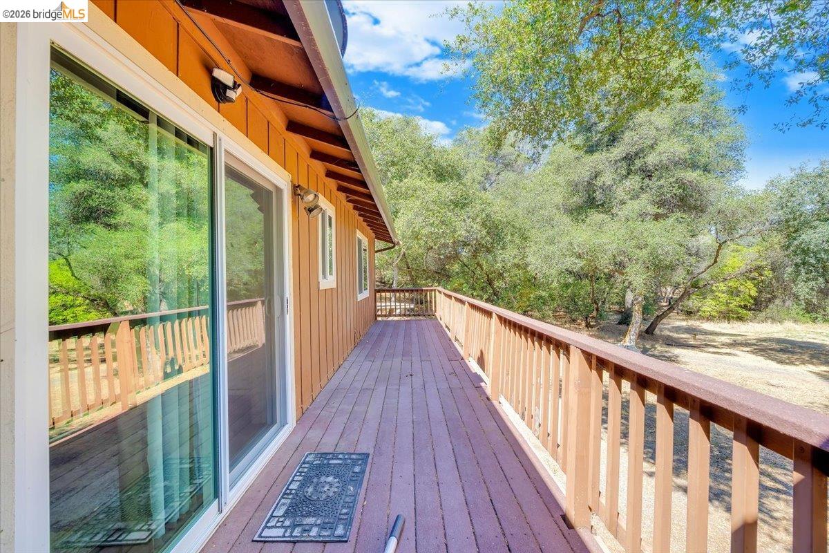 8733 Fraguero Road Sonora, CA 95370 - Photo 17 of 73 Expansive exterior deck featuring wood-finish flooring, a wood railing, and a clear glass sliding door