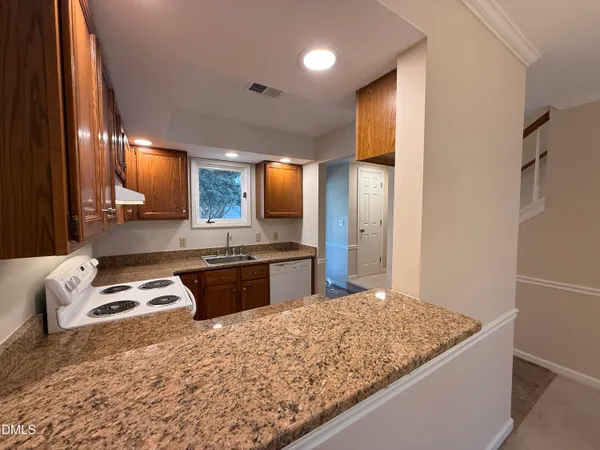 a kitchen with granite countertop a sink and a stove