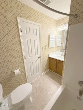 a picture of a white wall with a white comforter and pillows