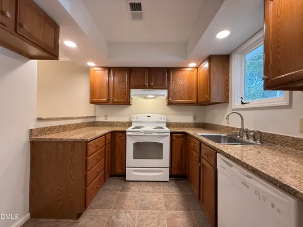 a kitchen with stainless steel appliances granite countertop sink stove and refrigerator