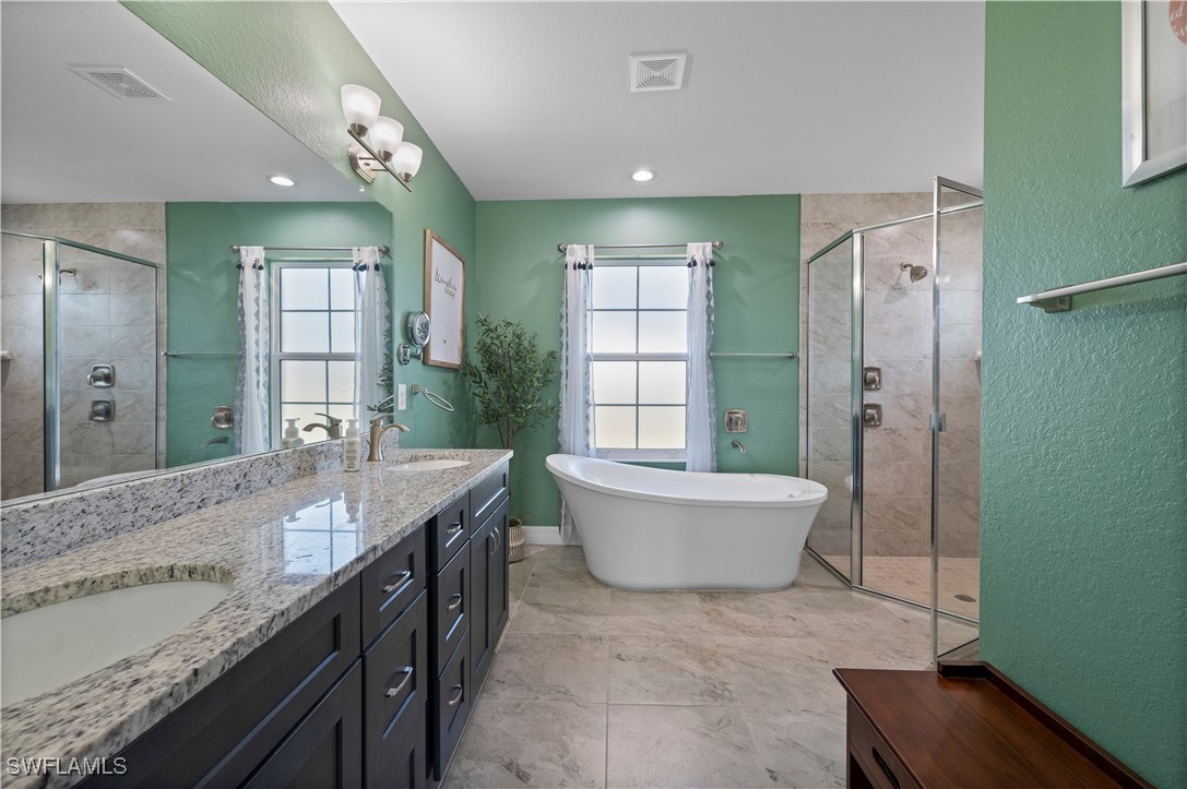 1606 Navigator Road Punta Gorda, FL 33983 - Photo 21 of 47 a spacious bathroom with a granite countertop tub sink and mirror