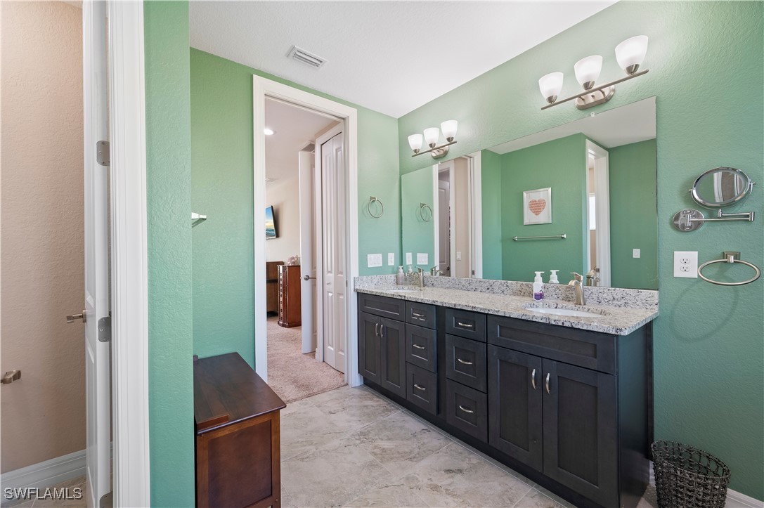 1606 Navigator Road Punta Gorda, FL 33983 - Photo 23 of 47 a spacious bathroom with a double vanity sink a large mirror and a shower
