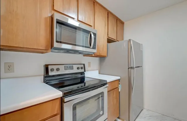 a kitchen with stainless steel appliances granite countertop a refrigerator stove and microwave
