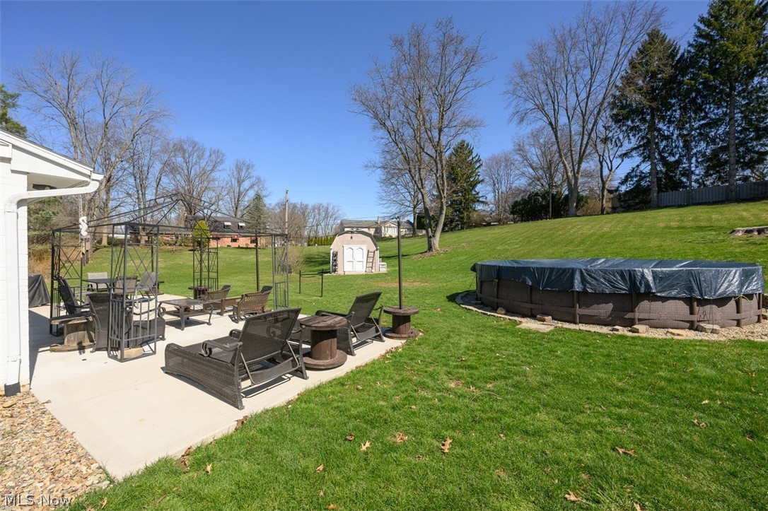2108 Devonshire Road Northwest Canton, OH 44708 - Photo 28 of 33 View of backyard with patio area, above ground pool, fire pit and storage shed