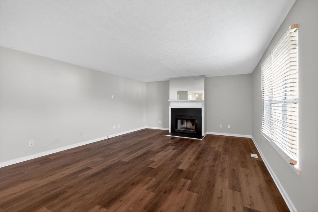 3737 Waldrop Road Decatur, GA 30034 - Photo 19 of 28 an empty room with wooden floor fireplace and windows