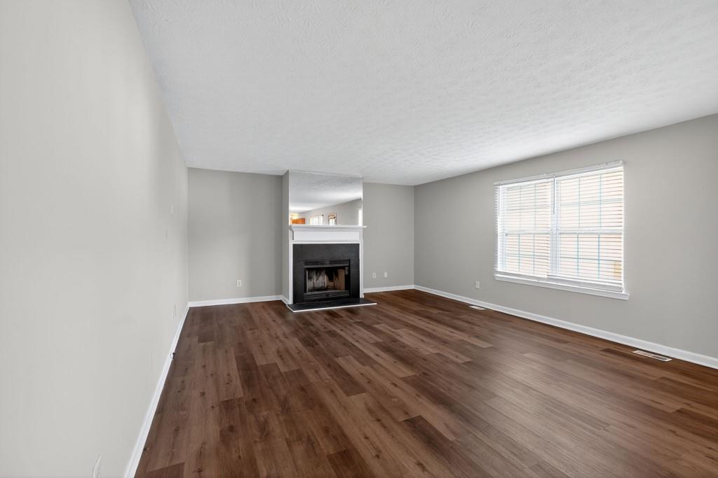 3737 Waldrop Road Decatur, GA 30034 - Photo 21 of 28 an empty room with windows fireplace and wooden floor