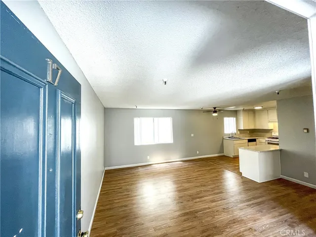 a view of a kitchen with a sink and dishwasher with wooden floor