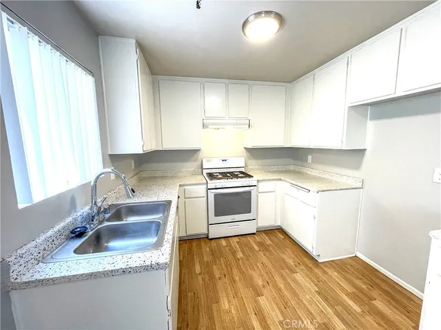 a kitchen with granite countertop white cabinets and white appliances