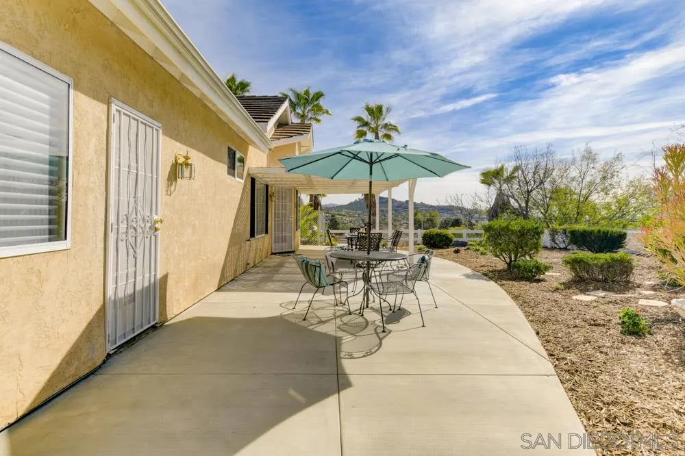 2762 Jody Place Escondido, CA 92027 - Photo 22 of 25 a view of a patio with a table and chairs under an umbrella