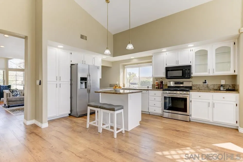2762 Jody Place Escondido, CA 92027 - Photo 8 of 25 a kitchen with white cabinets and stainless steel appliances