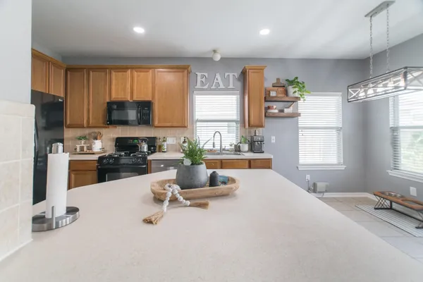 a kitchen with sink refrigerator and microwave