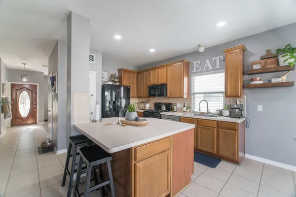 a kitchen with a sink a stove cabinets and a dining table
