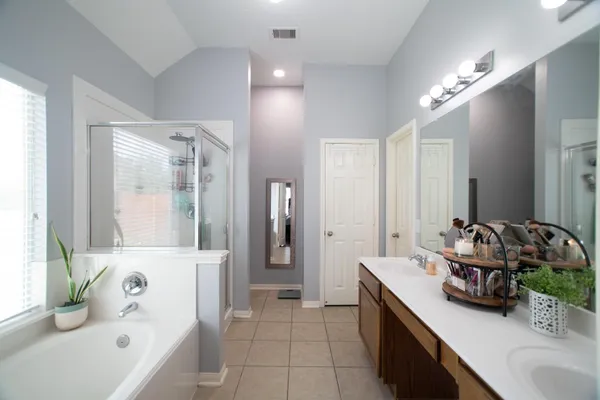 a bathroom with a tub sink and mirror