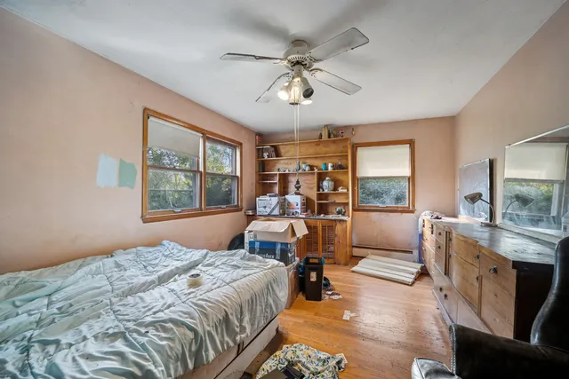 a bedroom with a bed and wooden floor
