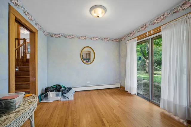 a view of a bedroom with natural light and wooden floor