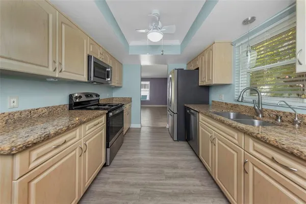 a kitchen with stainless steel appliances granite countertop lots of counter space a sink a stove and cabinets