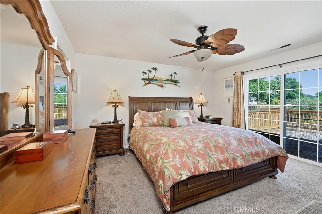 18650 Horseshoe Road Hidden Valley Lake, CA 95467 - Photo 16 of 26 a bedroom with a large bed and a chandelier