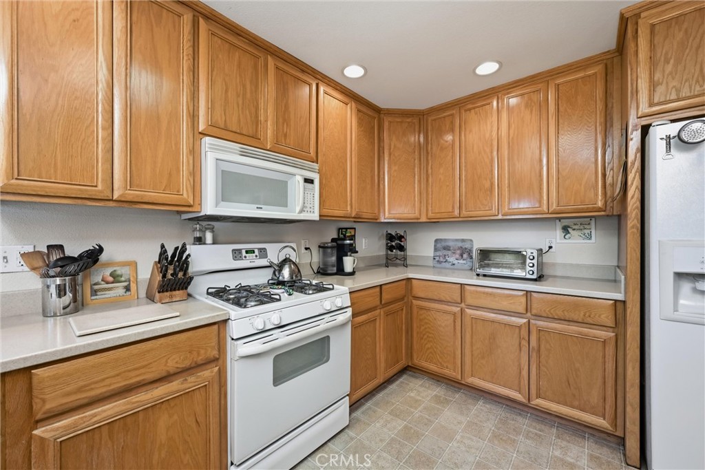 18650 Horseshoe Road Hidden Valley Lake, CA 95467 - Photo 9 of 26 a kitchen with stainless steel appliances granite countertop a stove a sink dishwasher and a refrigerator with wooden cabinets
