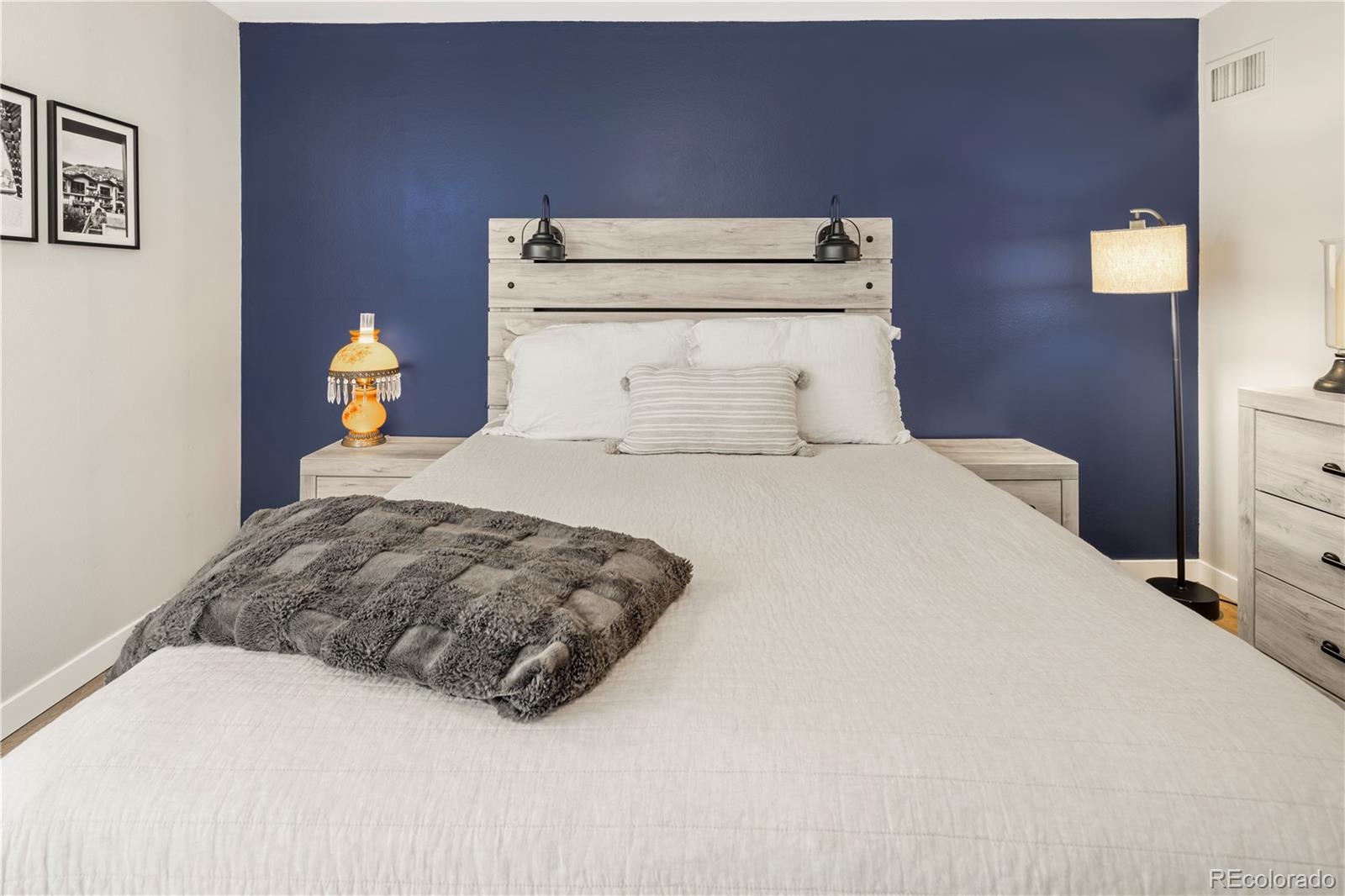 2 Adams Street, Unit 108 Denver, CO 80206 - Photo 19 of 36 a bedroom with a bed and a lamp