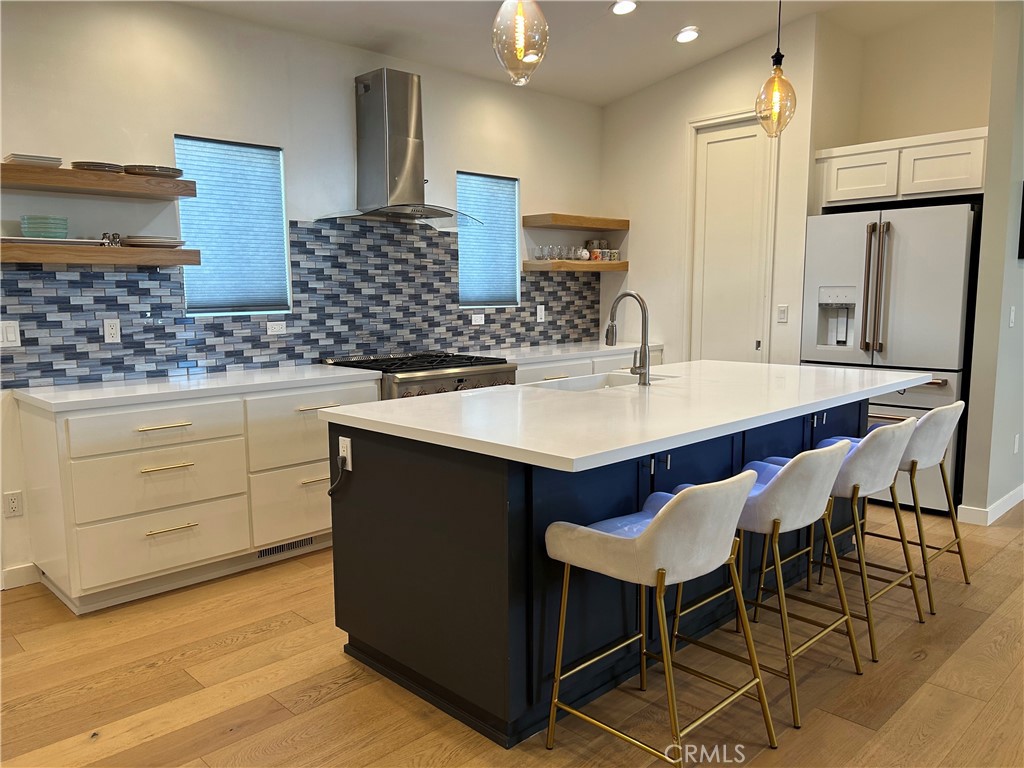 283 Cambridge Way Newport Beach, CA 92660 - Photo 5 of 33 a kitchen with stainless steel appliances kitchen island granite countertop a table chairs sink and cabinets
