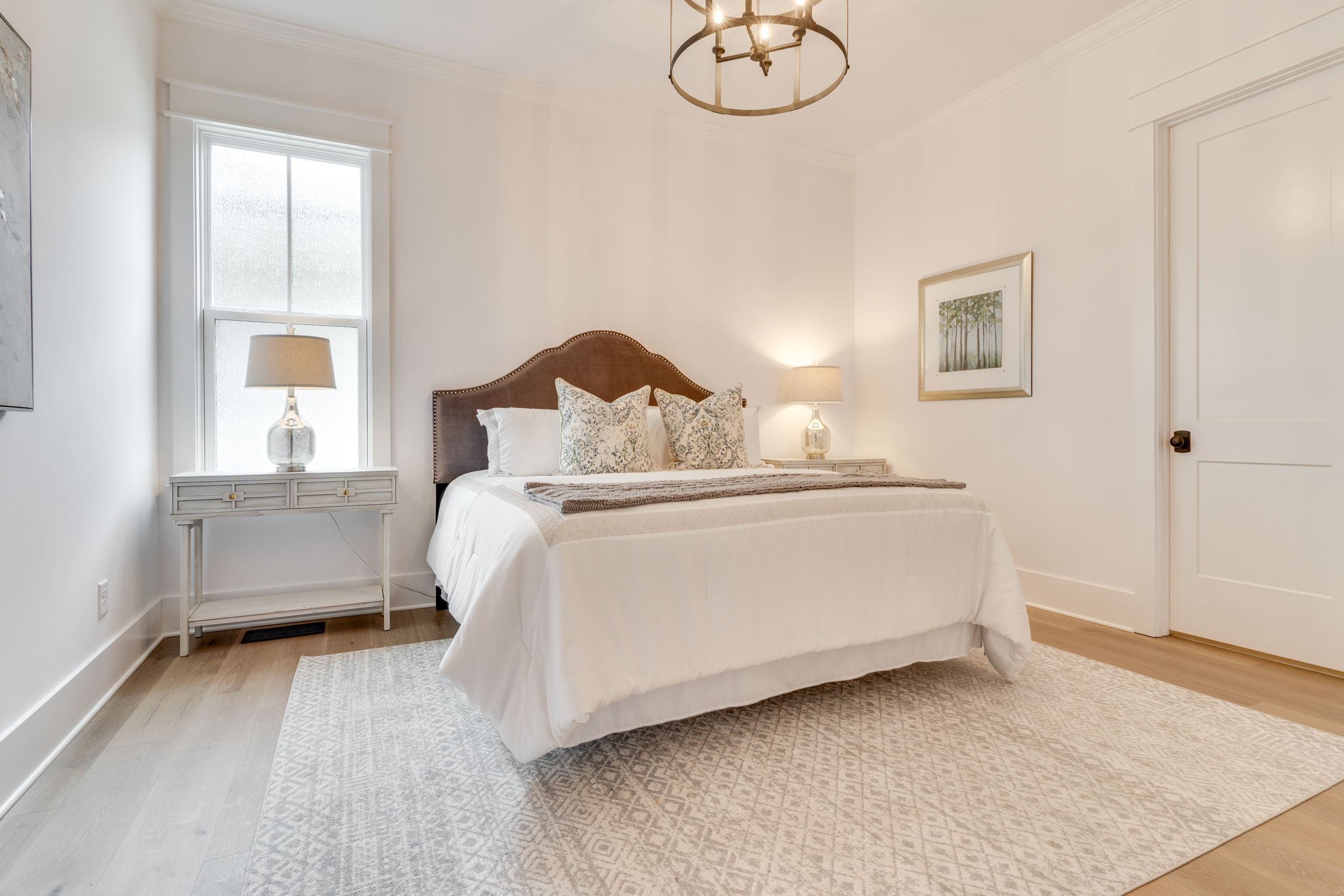 6076 Pasquo Road Nashville, TN 37221 - Photo 43 of 69 a bedroom with a bed and a chandelier