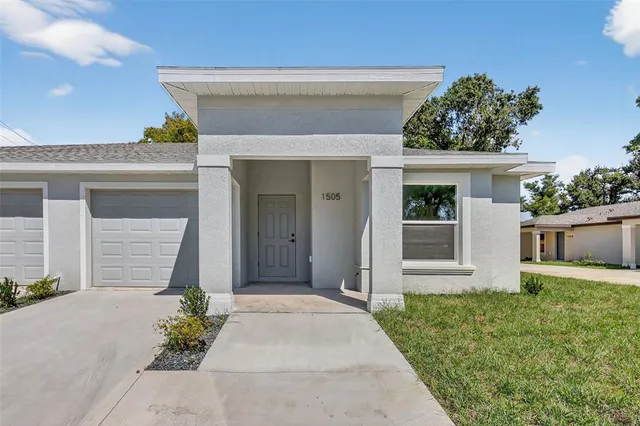 a front view of a house with a yard and garage