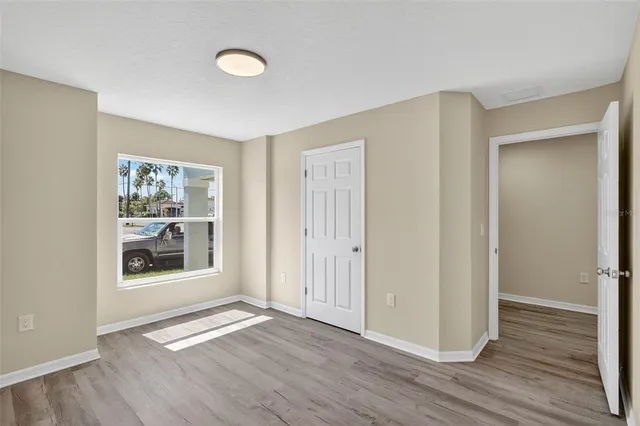 an empty room with wooden floor and windows