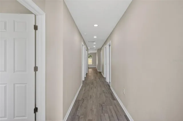 a view of a hallway with wooden floor