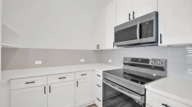 a kitchen with microwave cabinets and stove top oven