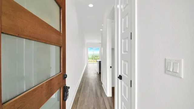 a view of a hallway with wooden floor and staircase