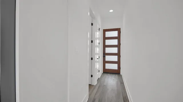 a view of a hallway with wooden floor and closet