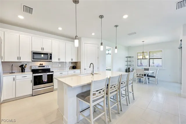 a large kitchen with kitchen island a dining table and chairs