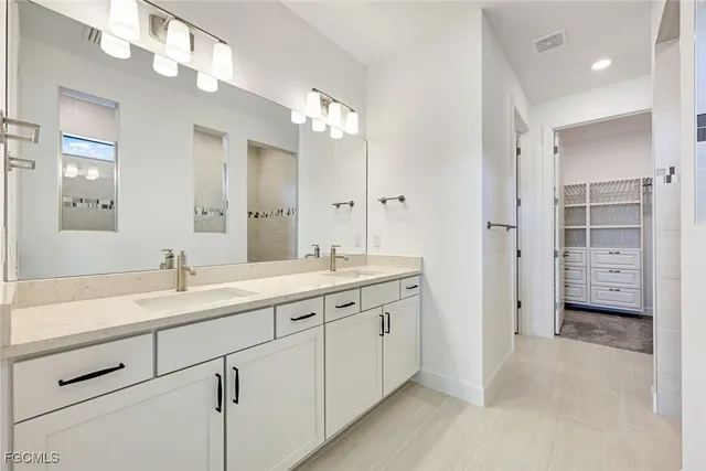 a bathroom with a double vanity sink a mirror and shower