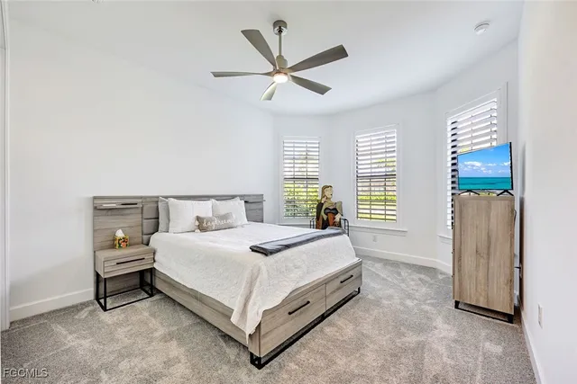 a bedroom with a bed and a ceiling fan