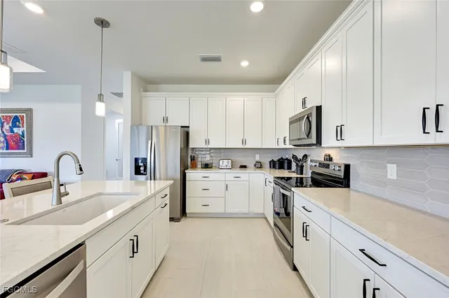 a kitchen with appliances a sink cabinets and a counter top space