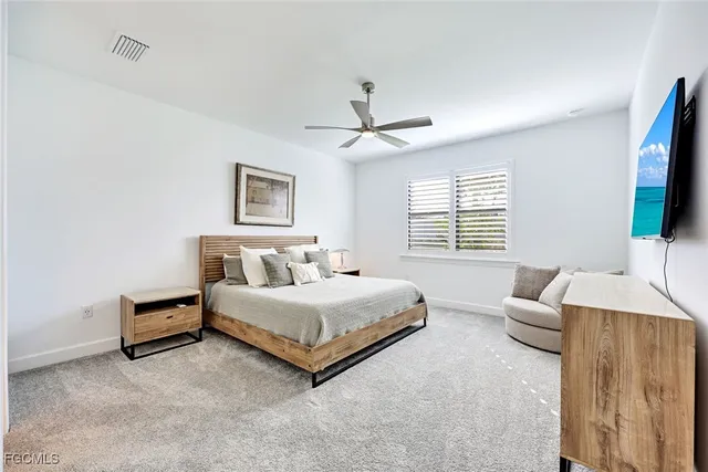 a spacious bedroom with a bed and a flat screen tv